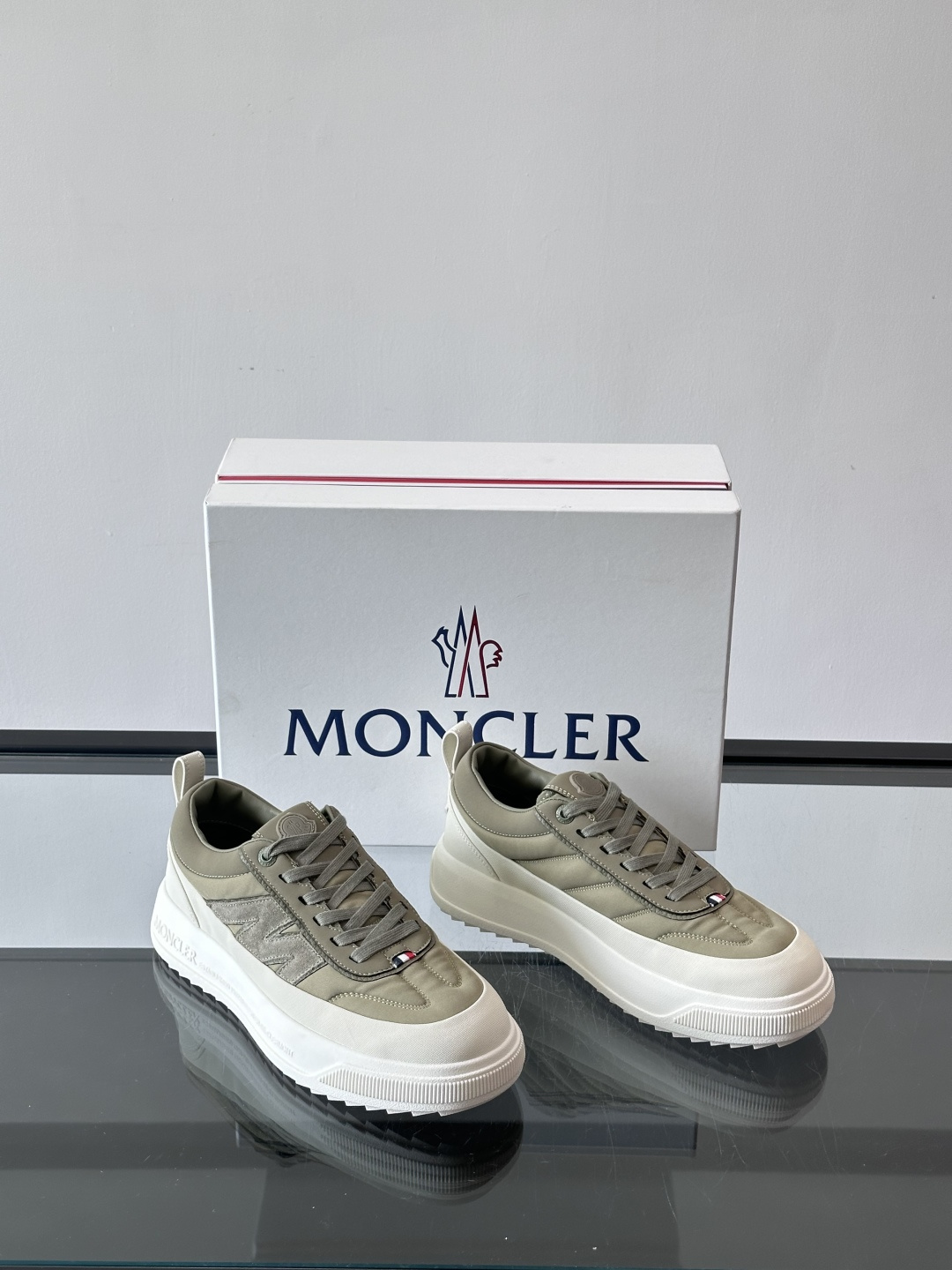 Moncler这款休闲运动鞋，主打简约百搭风，鞋面拼接米白+浅灰，蓝色橡胶鞋底和侧边点缀超有活力。鞋舌和