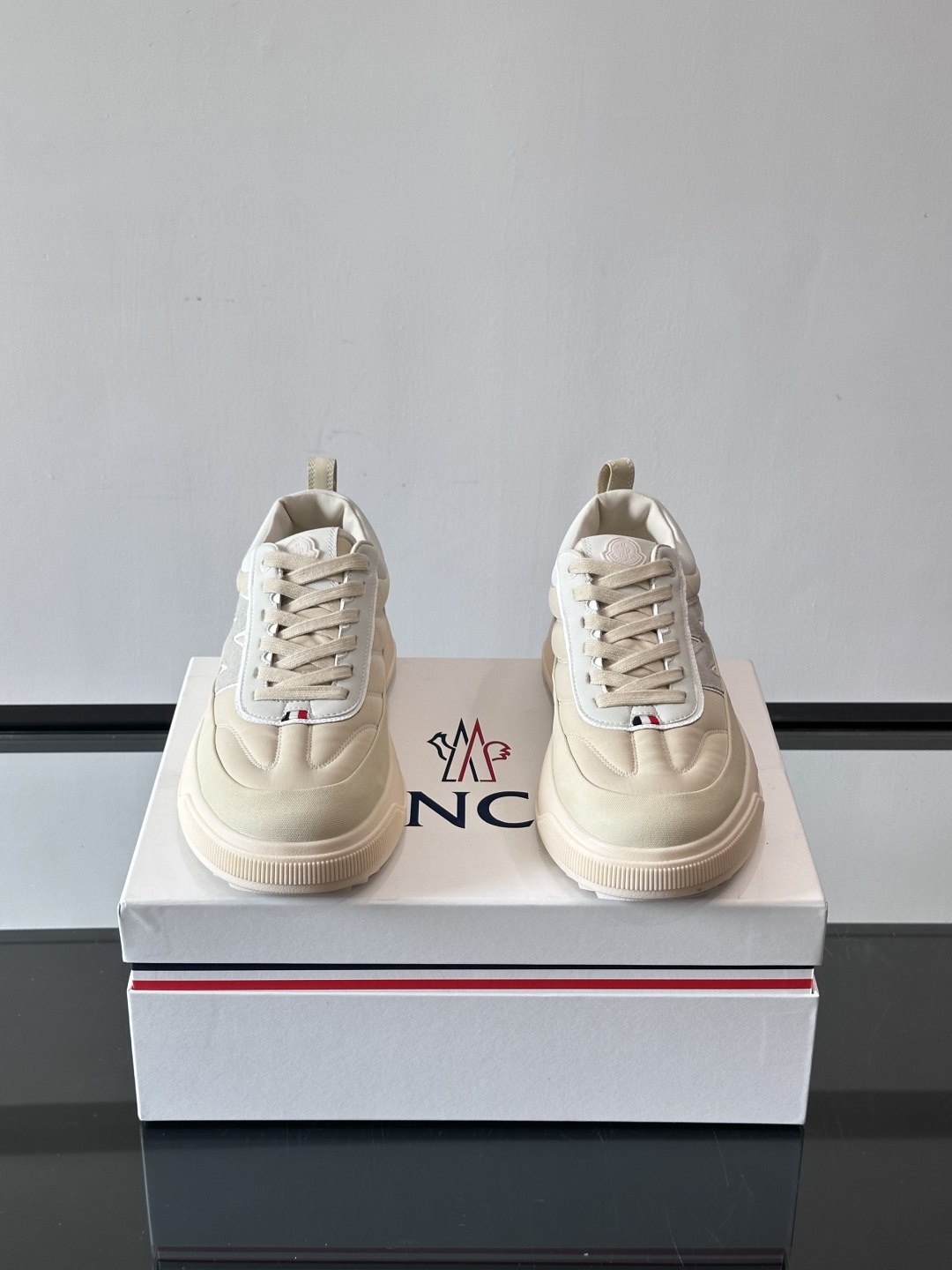 Moncler这款休闲运动鞋，主打简约百搭风，鞋面拼接米白+浅灰，蓝色橡胶鞋底和侧边点缀超有活力。鞋舌和