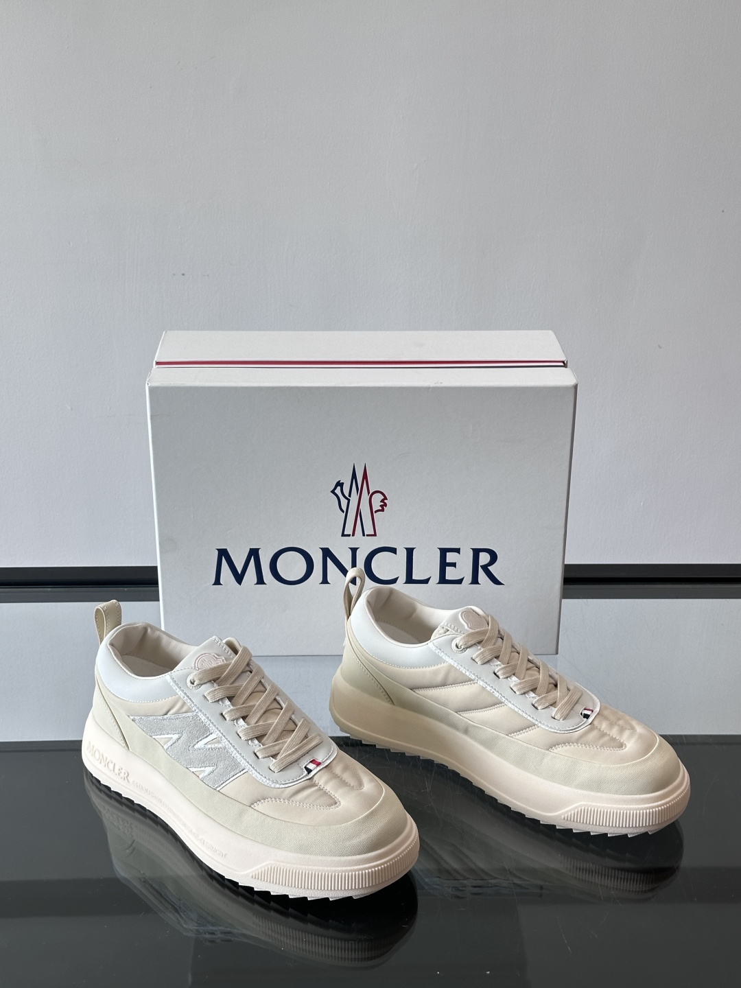 Moncler这款休闲运动鞋，主打简约百搭风，鞋面拼接米白+浅灰，蓝色橡胶鞋底和侧边点缀超有活力。鞋舌和