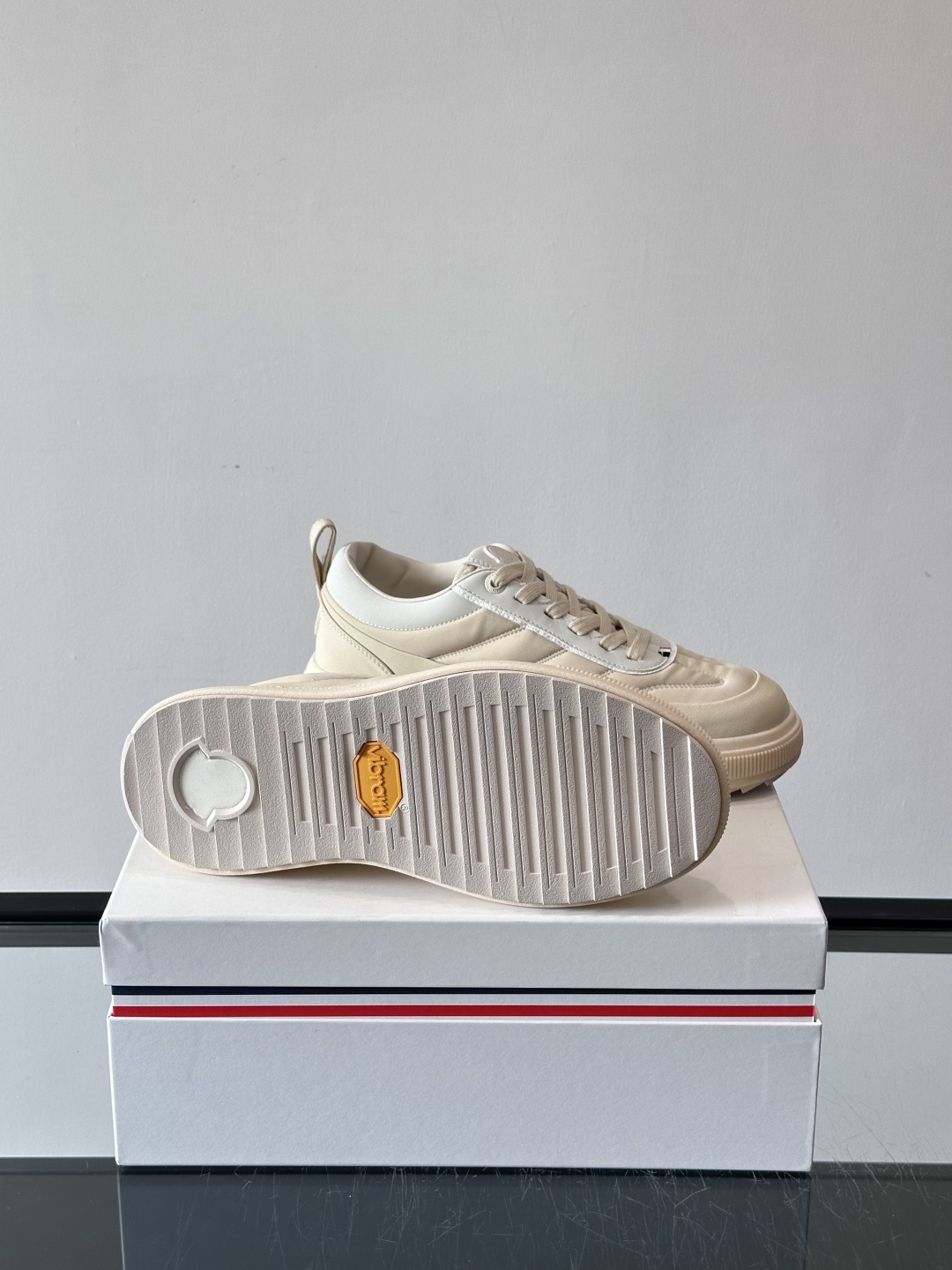 Moncler这款休闲运动鞋，主打简约百搭风，鞋面拼接米白+浅灰，蓝色橡胶鞋底和侧边点缀超有活力。鞋舌和