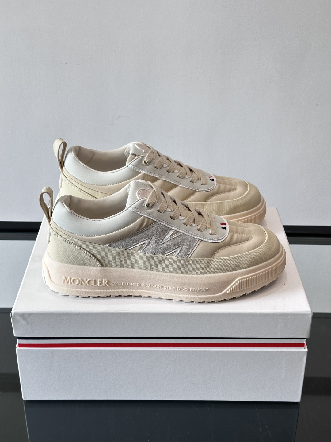 Moncler这款休闲运动鞋，主打简约百搭风，鞋面拼接米白+浅灰，蓝色橡胶鞋底和侧边点缀超有活力。鞋舌和