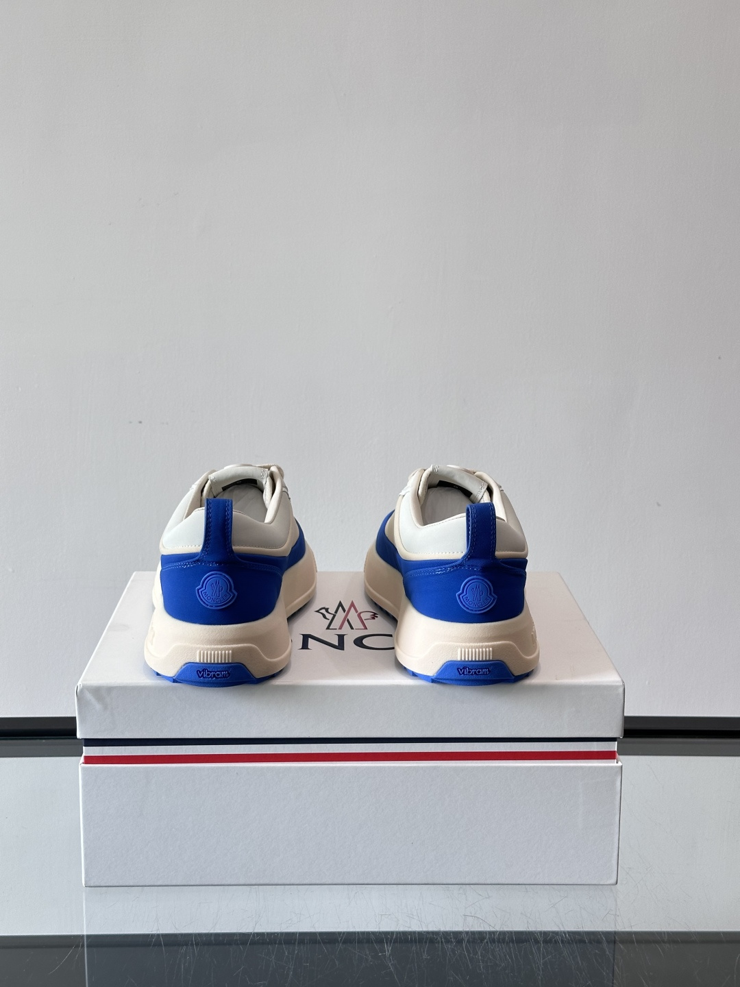 Moncler这款休闲运动鞋，主打简约百搭风，鞋面拼接米白+浅灰，蓝色橡胶鞋底和侧边点缀超有活力。鞋舌和