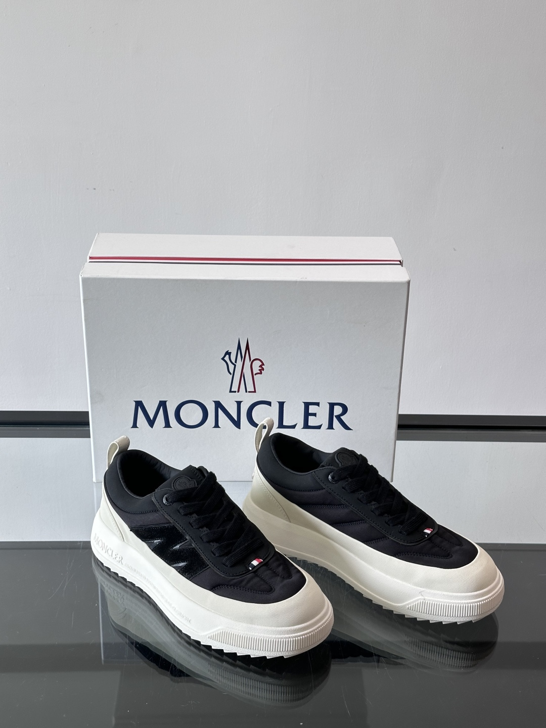 Moncler这款休闲运动鞋，主打简约百搭风，鞋面拼接米白+浅灰，蓝色橡胶鞋底和侧边点缀超有活力。鞋舌和