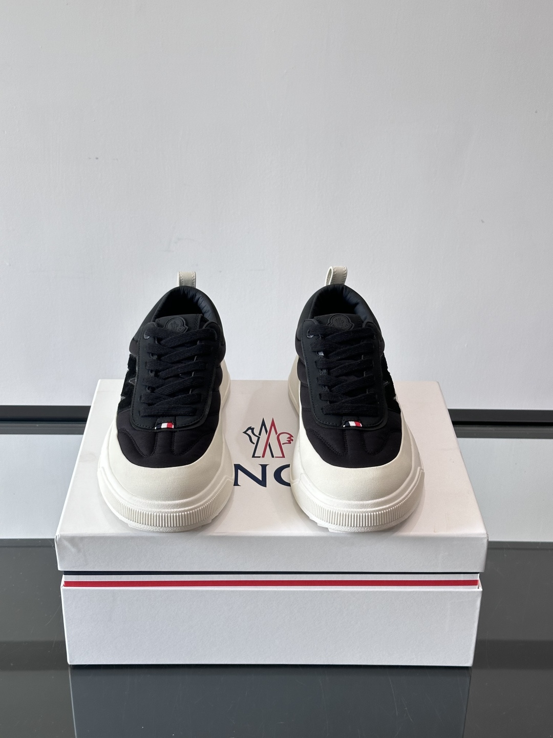 Moncler这款休闲运动鞋，主打简约百搭风，鞋面拼接米白+浅灰，蓝色橡胶鞋底和侧边点缀超有活力。鞋舌和