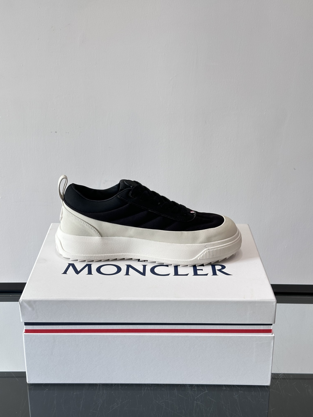 Moncler这款休闲运动鞋，主打简约百搭风，鞋面拼接米白+浅灰，蓝色橡胶鞋底和侧边点缀超有活力。鞋舌和