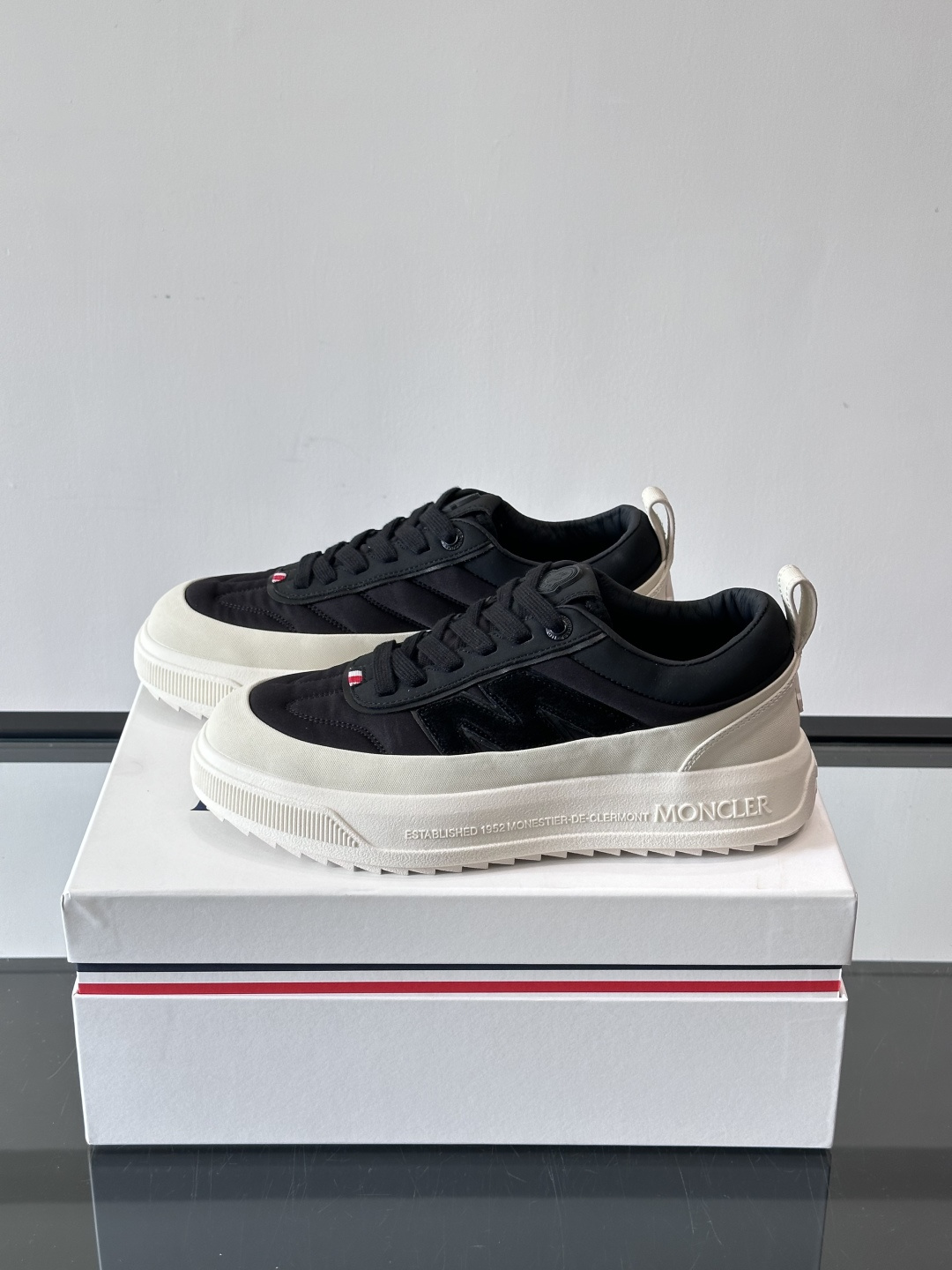 Moncler这款休闲运动鞋，主打简约百搭风，鞋面拼接米白+浅灰，蓝色橡胶鞋底和侧边点缀超有活力。鞋舌和