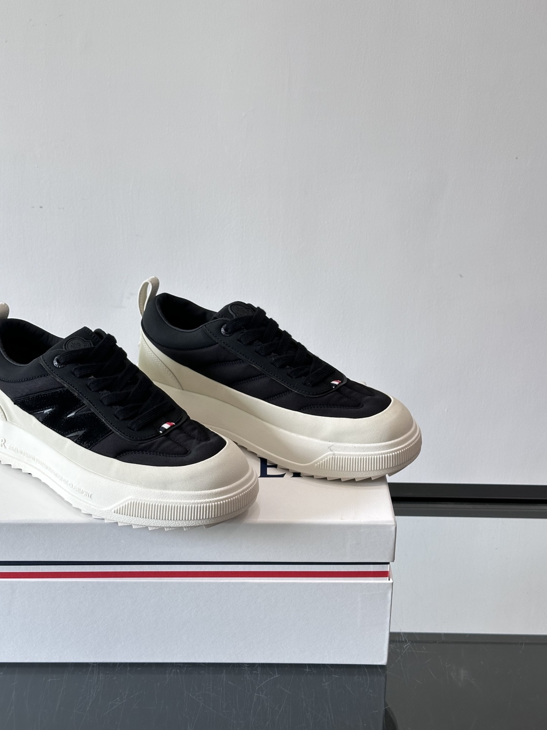 Moncler这款休闲运动鞋，主打简约百搭风，鞋面拼接米白+浅灰，蓝色橡胶鞋底和侧边点缀超有活力。鞋舌和