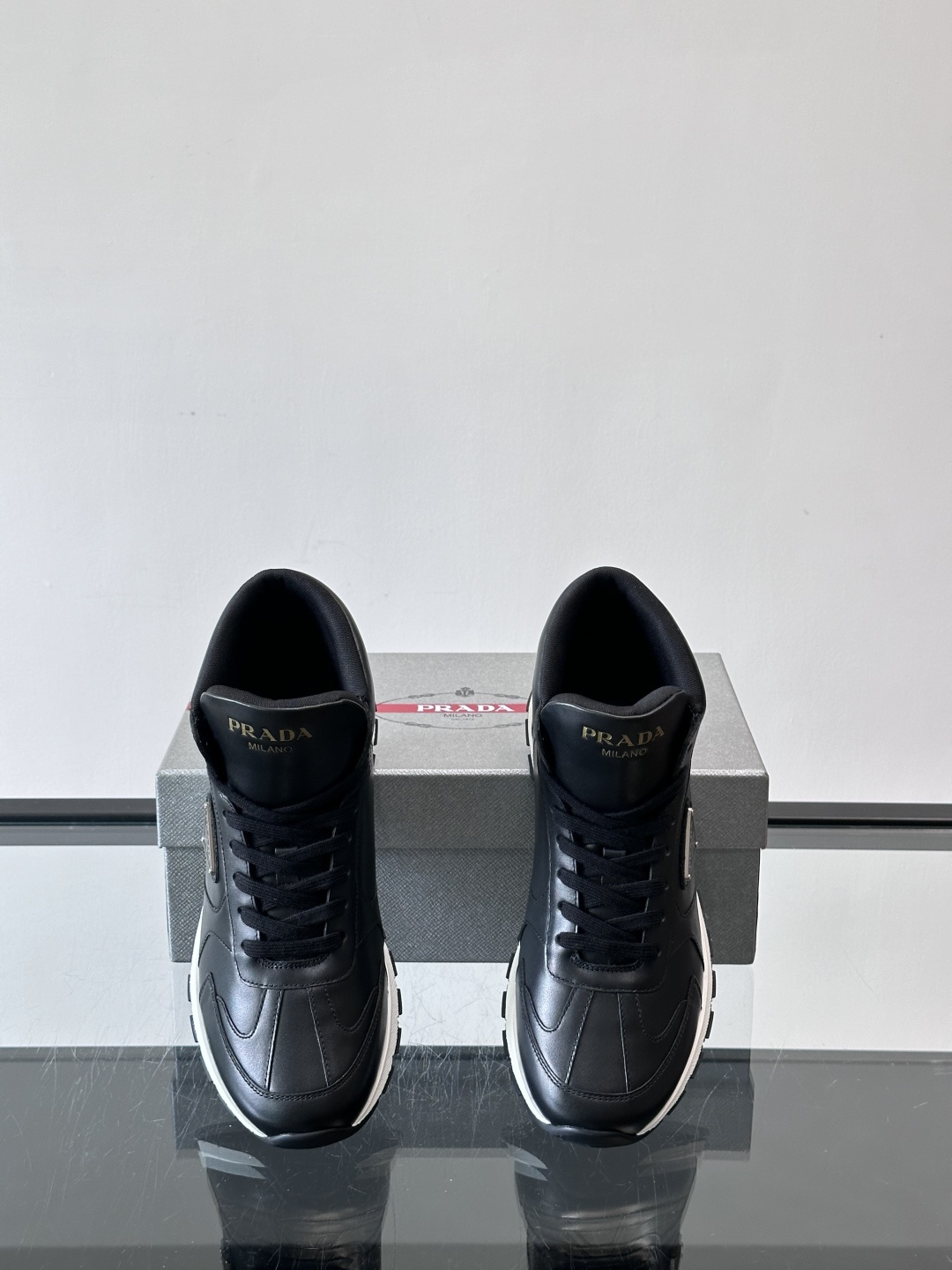 PRADA/普拉达 男士新款高帮运动鞋，这款厚底运动鞋采用牛皮鞋面制成，搭配加厚橡胶发泡中底拼接前后包裹