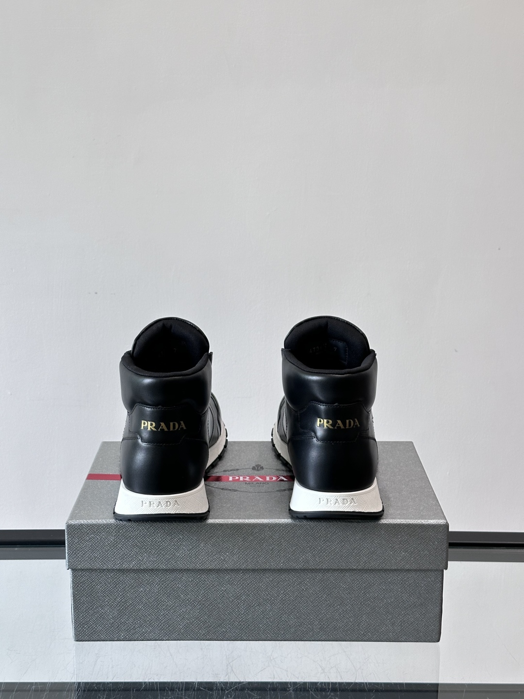 PRADA/普拉达 男士新款高帮运动鞋，这款厚底运动鞋采用牛皮鞋面制成，搭配加厚橡胶发泡中底拼接前后包裹