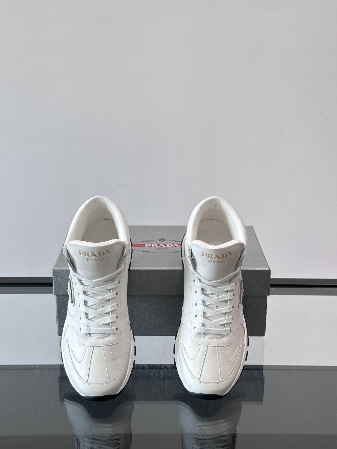 PRADA/普拉达 男士新款高帮运动鞋，这款厚底运动鞋采用牛皮鞋面制成，搭配加厚橡胶发泡中底拼接前后包裹