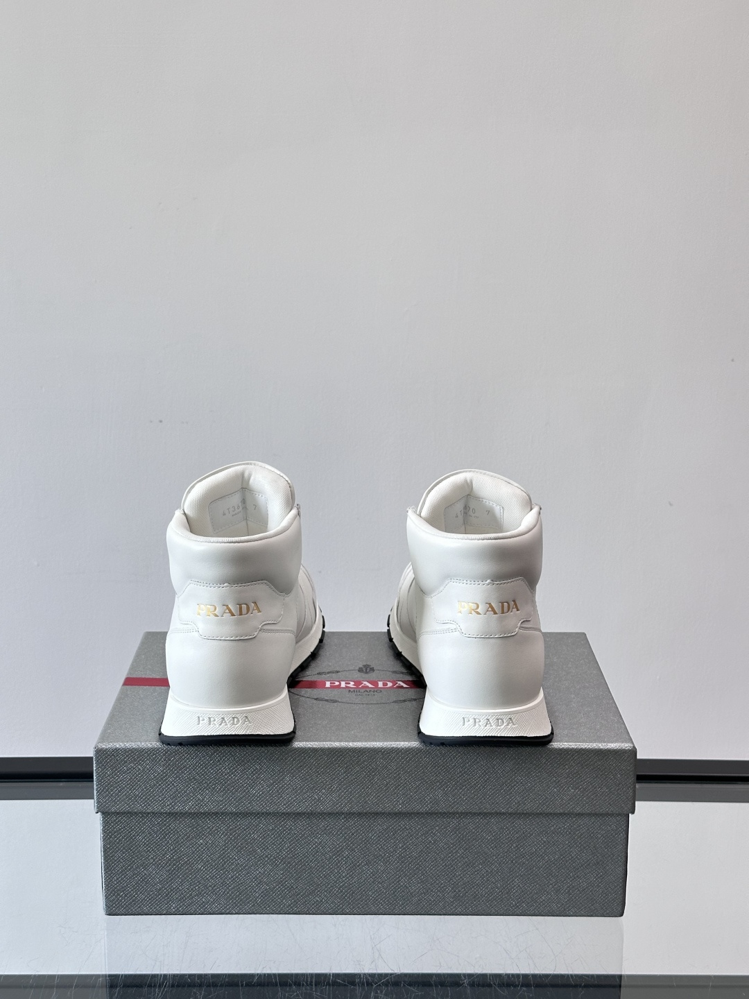 PRADA/普拉达 男士新款高帮运动鞋，这款厚底运动鞋采用牛皮鞋面制成，搭配加厚橡胶发泡中底拼接前后包裹
