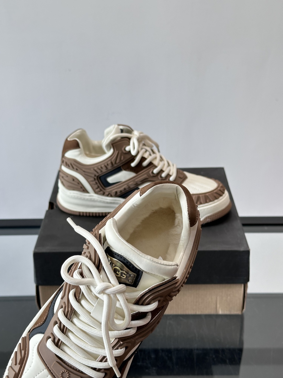 UGG 黑白拼接运动鞋​​🖤这款UGG黑白拼接运动鞋，采用皮革搭配柔软羊毛内衬，穿着舒适又保暖✨。厚底橡