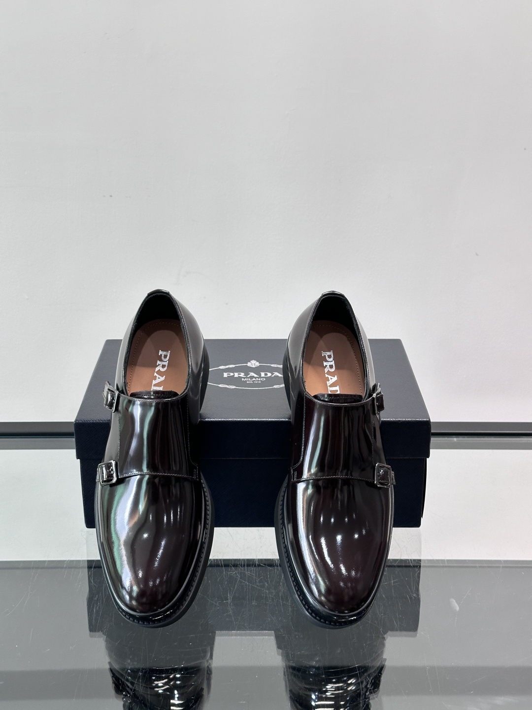 Prada双扣孟克皮鞋采用牛漆皮，光泽感满满，质感高级✨。标志性双扣带设计，金属扣件精致耐用，细节感十足