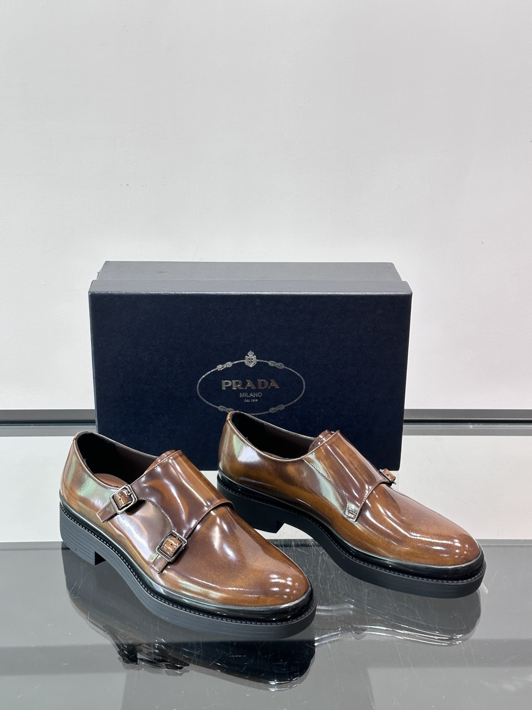 Prada双扣孟克皮鞋采用牛漆皮，光泽感满满，质感高级✨。标志性双扣带设计，金属扣件精致耐用，细节感十足