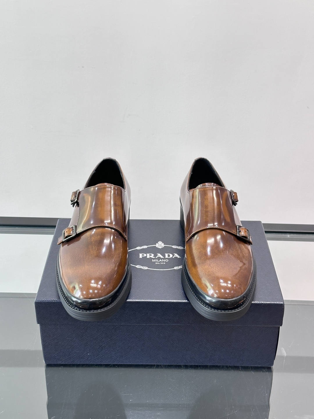 Prada双扣孟克皮鞋采用牛漆皮，光泽感满满，质感高级✨。标志性双扣带设计，金属扣件精致耐用，细节感十足