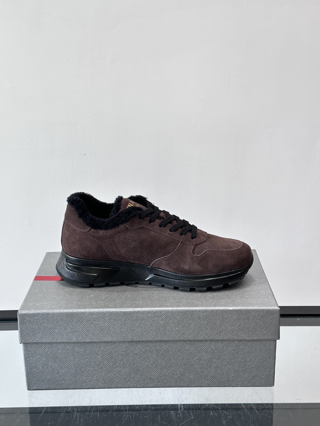 Prada新款翻毛牛皮天鹅绒运动鞋这款以绒面小牛皮打造的运动鞋完美地结合了复古韵味与现代审美。其鞋舌由柔