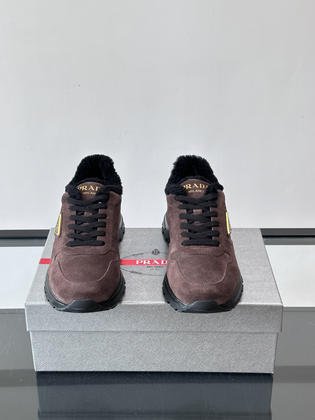 Prada新款翻毛牛皮天鹅绒运动鞋这款以绒面小牛皮打造的运动鞋完美地结合了复古韵味与现代审美。其鞋舌由柔