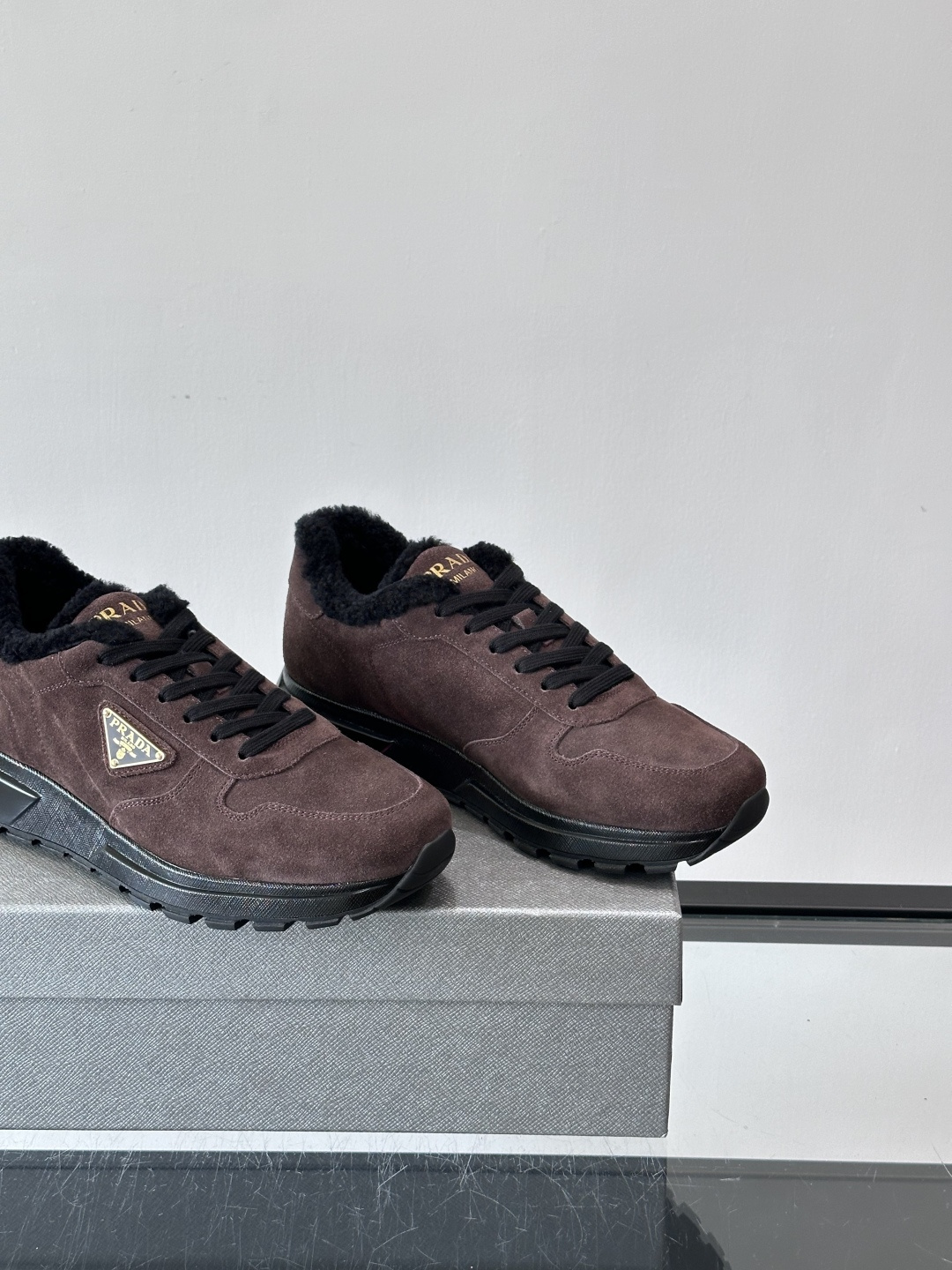 Prada新款翻毛牛皮天鹅绒运动鞋这款以绒面小牛皮打造的运动鞋完美地结合了复古韵味与现代审美。其鞋舌由柔
