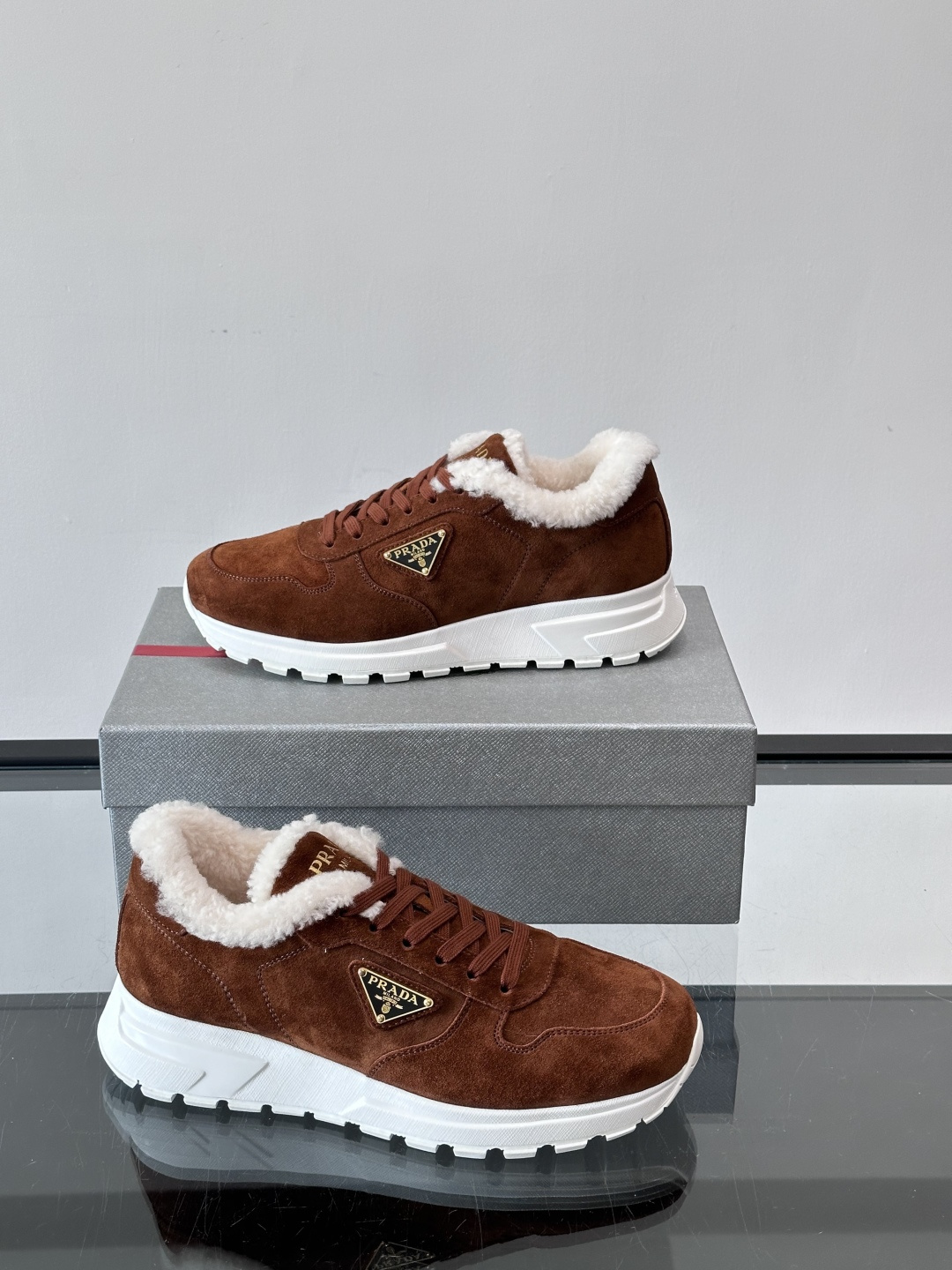 Prada新款翻毛牛皮天鹅绒运动鞋这款以绒面小牛皮打造的运动鞋完美地结合了复古韵味与现代审美。其鞋舌由柔