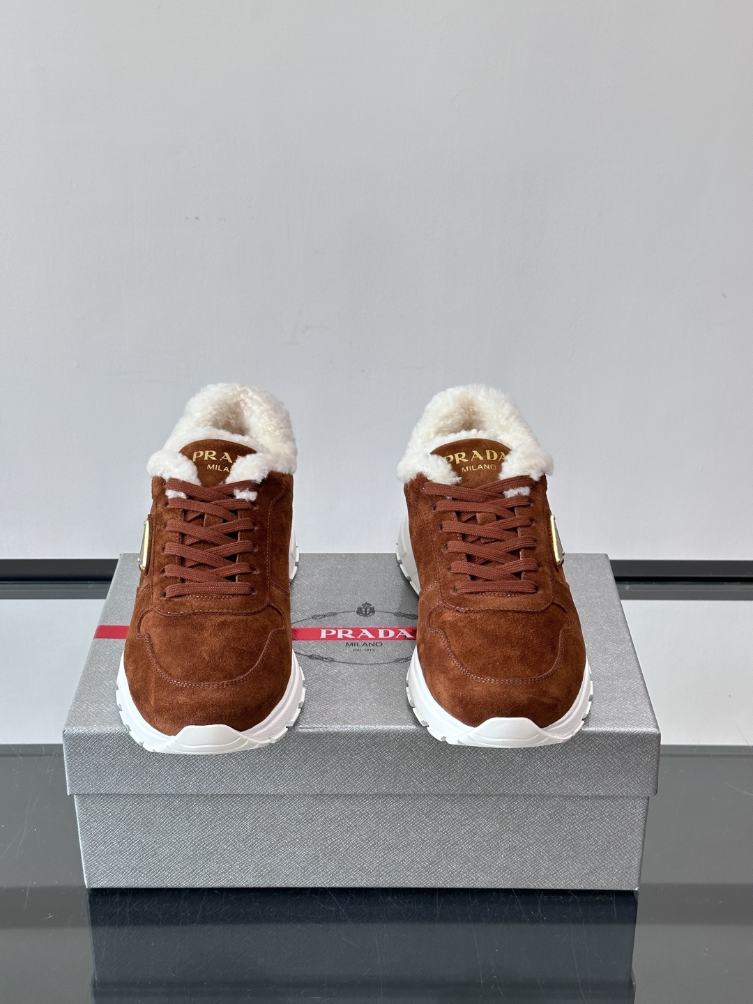 Prada新款翻毛牛皮天鹅绒运动鞋这款以绒面小牛皮打造的运动鞋完美地结合了复古韵味与现代审美。其鞋舌由柔