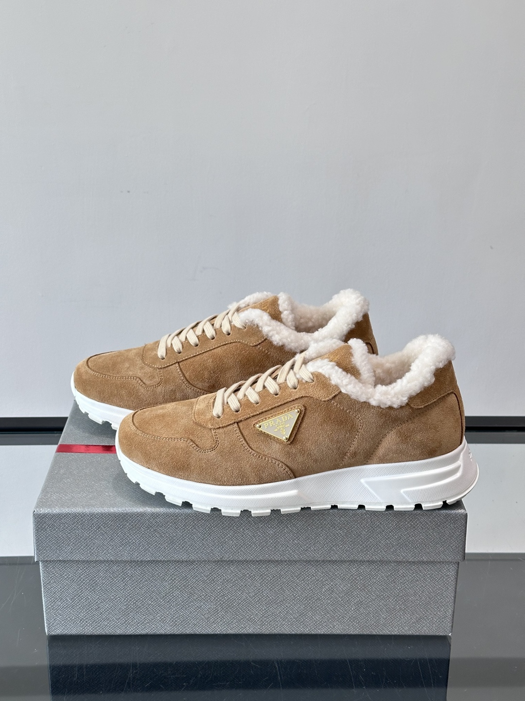 Prada新款翻毛牛皮天鹅绒运动鞋这款以绒面小牛皮打造的运动鞋完美地结合了复古韵味与现代审美。其鞋舌由柔