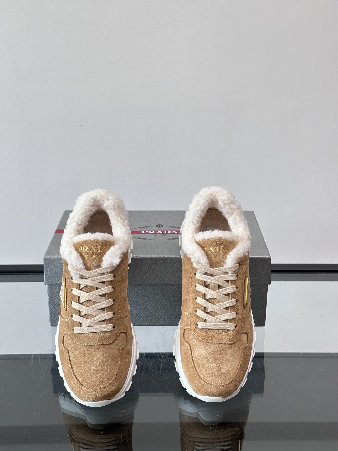 Prada新款翻毛牛皮天鹅绒运动鞋这款以绒面小牛皮打造的运动鞋完美地结合了复古韵味与现代审美。其鞋舌由柔