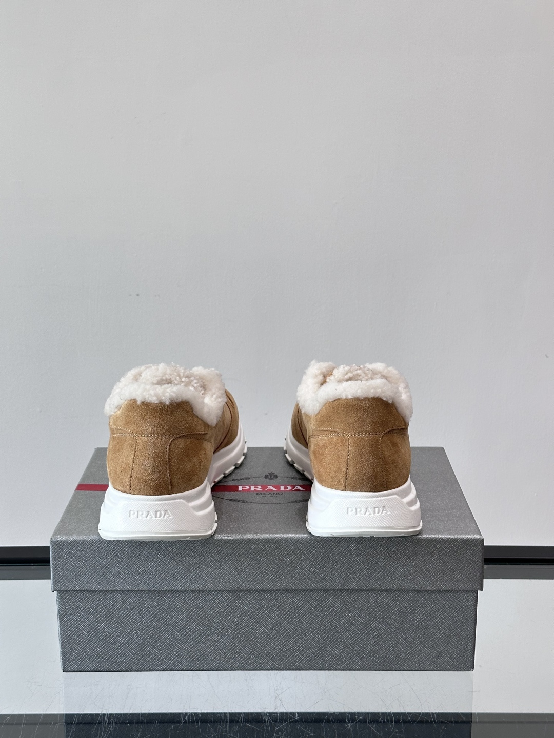 Prada新款翻毛牛皮天鹅绒运动鞋这款以绒面小牛皮打造的运动鞋完美地结合了复古韵味与现代审美。其鞋舌由柔