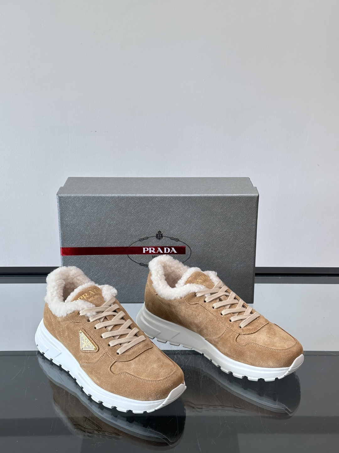 Prada新款翻毛牛皮天鹅绒运动鞋这款以绒面小牛皮打造的运动鞋完美地结合了复古韵味与现代审美。其鞋舌由柔
