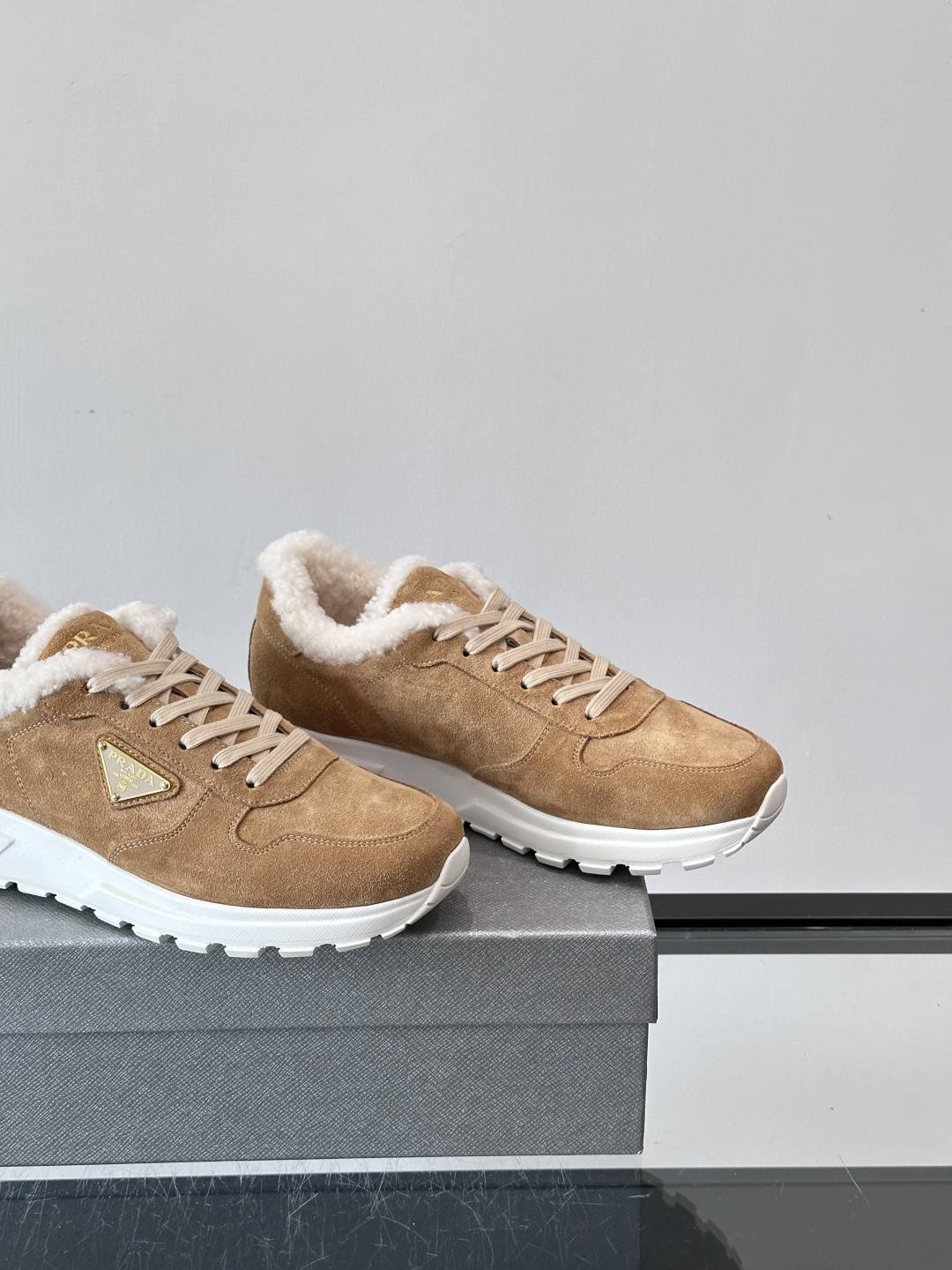 Prada新款翻毛牛皮天鹅绒运动鞋这款以绒面小牛皮打造的运动鞋完美地结合了复古韵味与现代审美。其鞋舌由柔