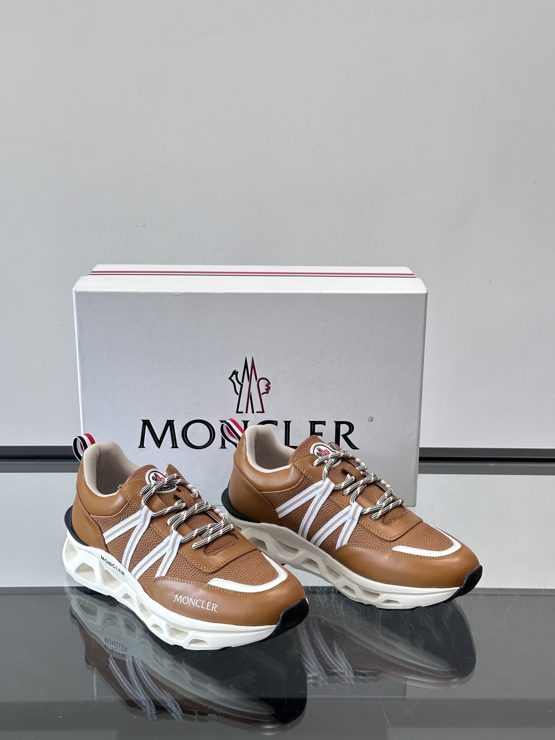 Moncler男士休闲运动鞋，采用优质皮革＋装饰织物拼接，搭配白色线条，简约又有运动感。橡胶鞋底抓地力强