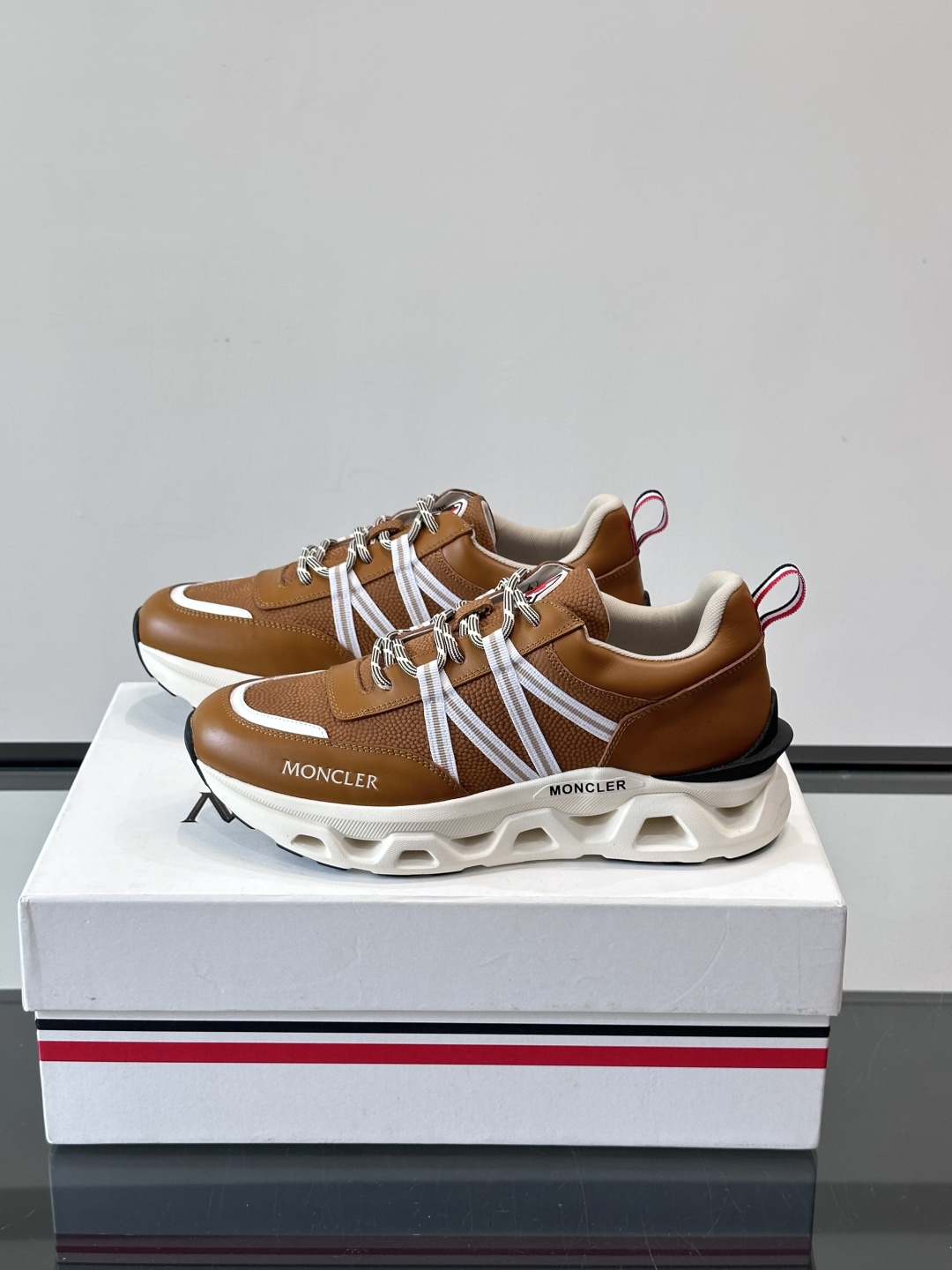 Moncler男士休闲运动鞋，采用优质皮革＋装饰织物拼接，搭配白色线条，简约又有运动感。橡胶鞋底抓地力强