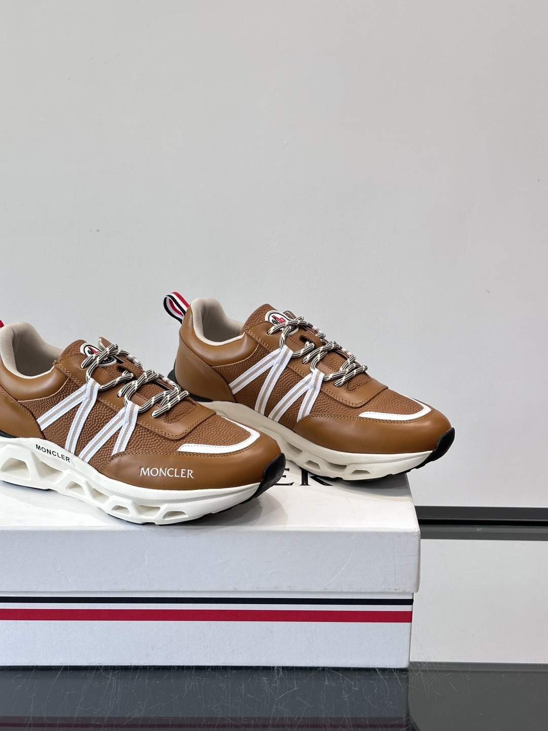 Moncler男士休闲运动鞋，采用优质皮革＋装饰织物拼接，搭配白色线条，简约又有运动感。橡胶鞋底抓地力强