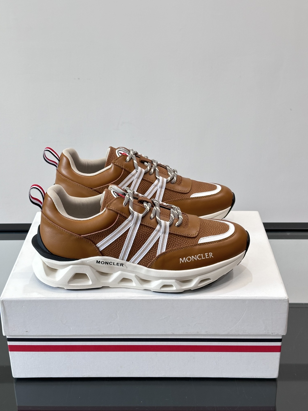 Moncler男士休闲运动鞋，采用优质皮革＋装饰织物拼接，搭配白色线条，简约又有运动感。橡胶鞋底抓地力强