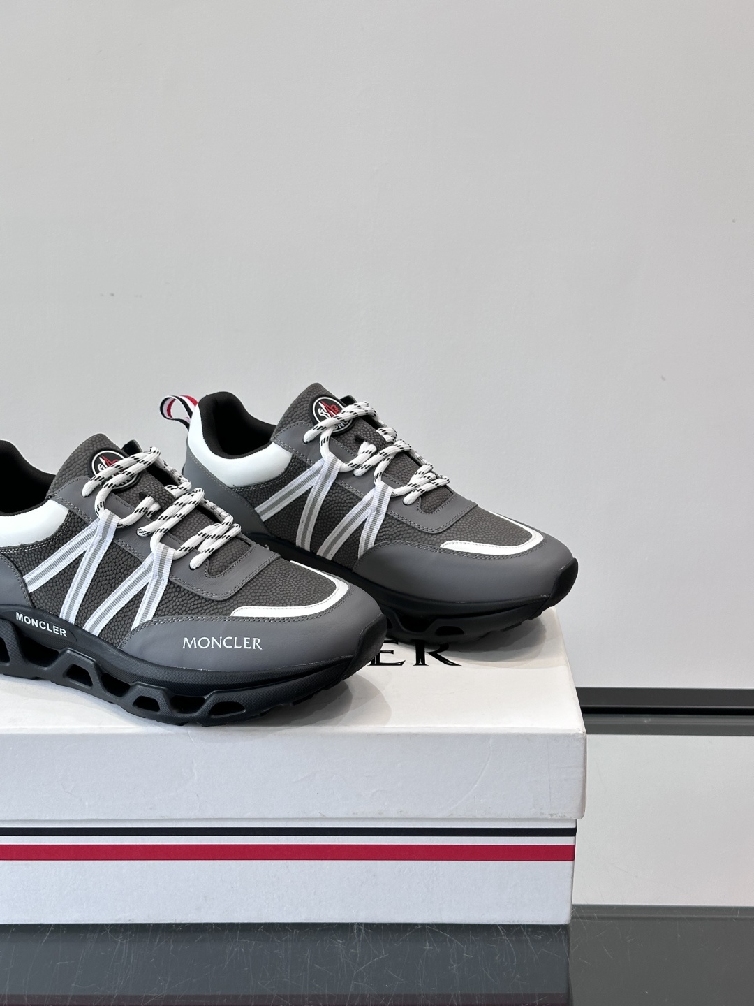 Moncler男士休闲运动鞋，采用优质皮革＋装饰织物拼接，搭配白色线条，简约又有运动感。橡胶鞋底抓地力强
