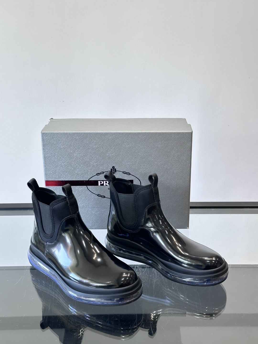 Prad*亮面切尔西靴，采用高光泽皮革，搭配松紧设计，穿脱超方便！厚底设计不仅增高，还很舒适，日常通勤或