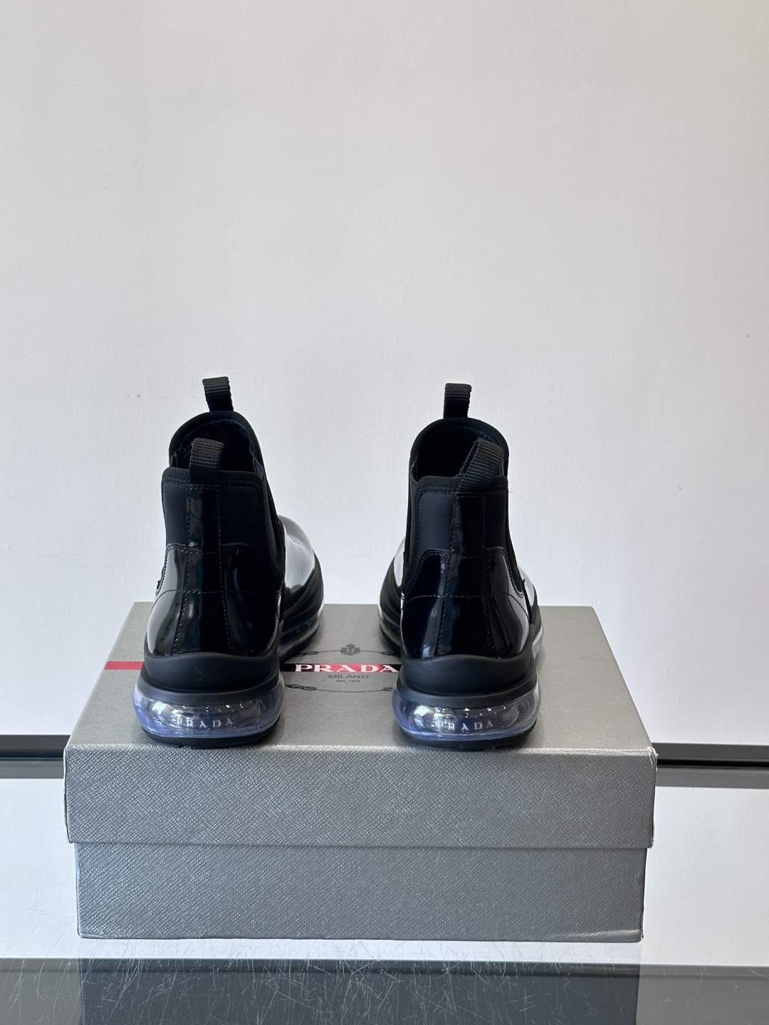 Prad*亮面切尔西靴，采用高光泽皮革，搭配松紧设计，穿脱超方便！厚底设计不仅增高，还很舒适，日常通勤或