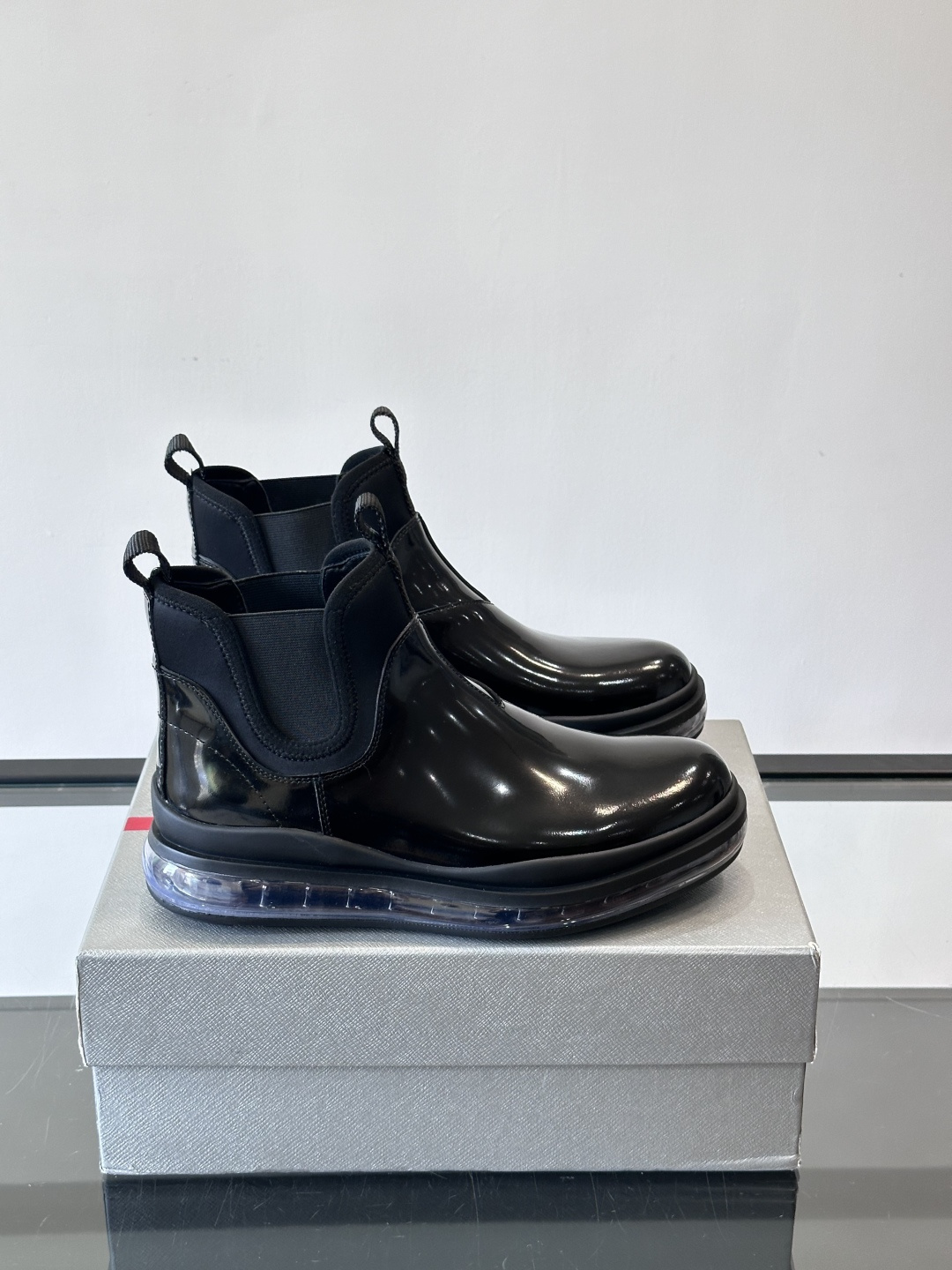 Prad*亮面切尔西靴，采用高光泽皮革，搭配松紧设计，穿脱超方便！厚底设计不仅增高，还很舒适，日常通勤或