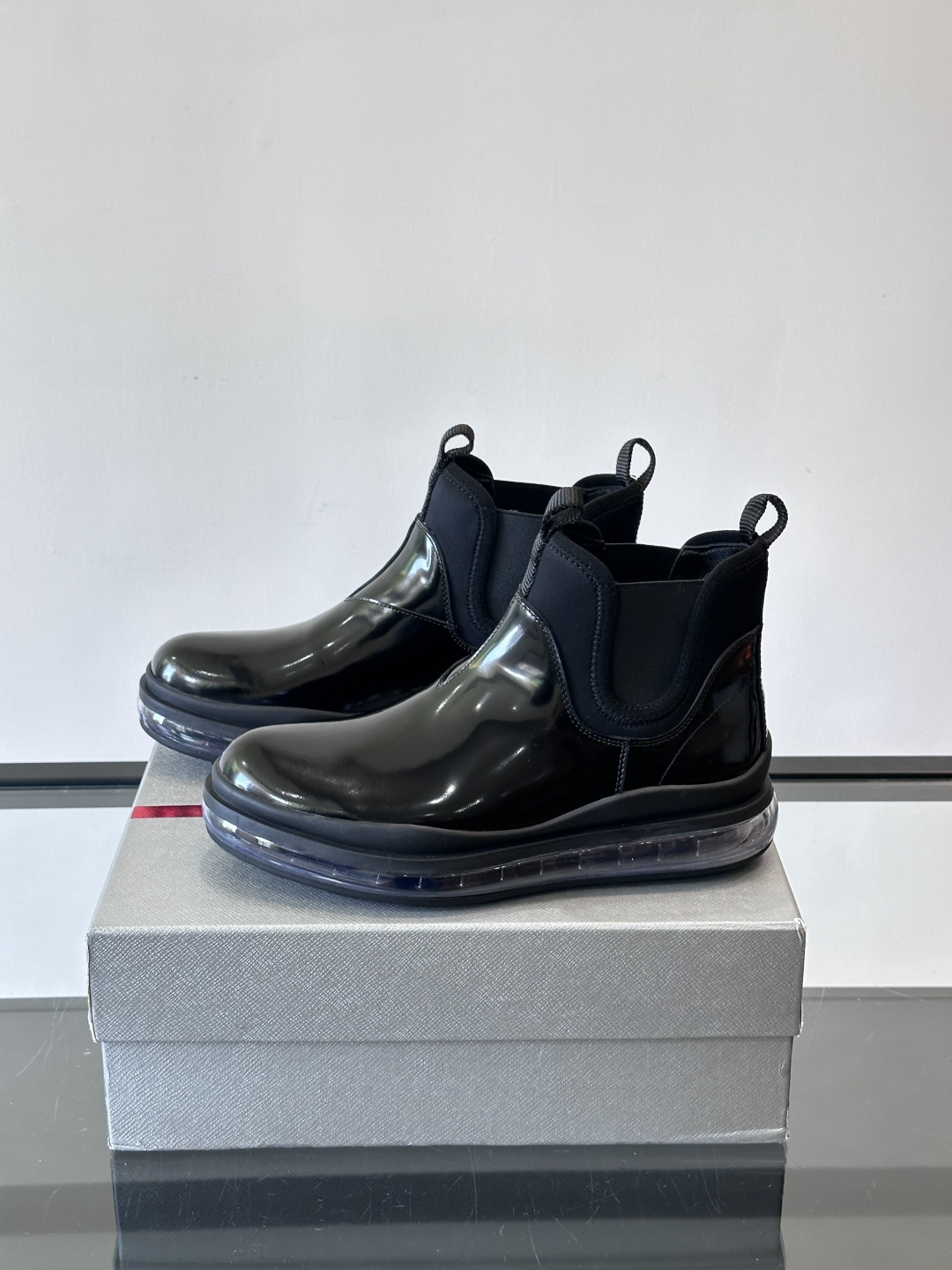 Prad*亮面切尔西靴，采用高光泽皮革，搭配松紧设计，穿脱超方便！厚底设计不仅增高，还很舒适，日常通勤或