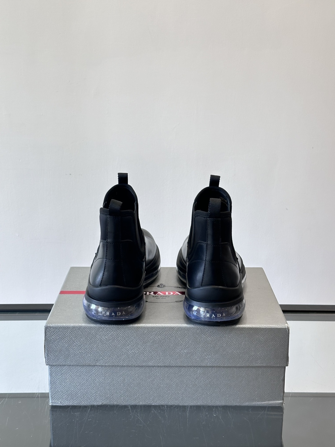Prad*亮面切尔西靴，采用高光泽皮革，搭配松紧设计，穿脱超方便！厚底设计不仅增高，还很舒适，日常通勤或
