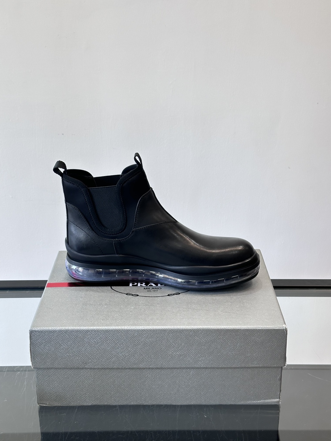 Prad*亮面切尔西靴，采用高光泽皮革，搭配松紧设计，穿脱超方便！厚底设计不仅增高，还很舒适，日常通勤或