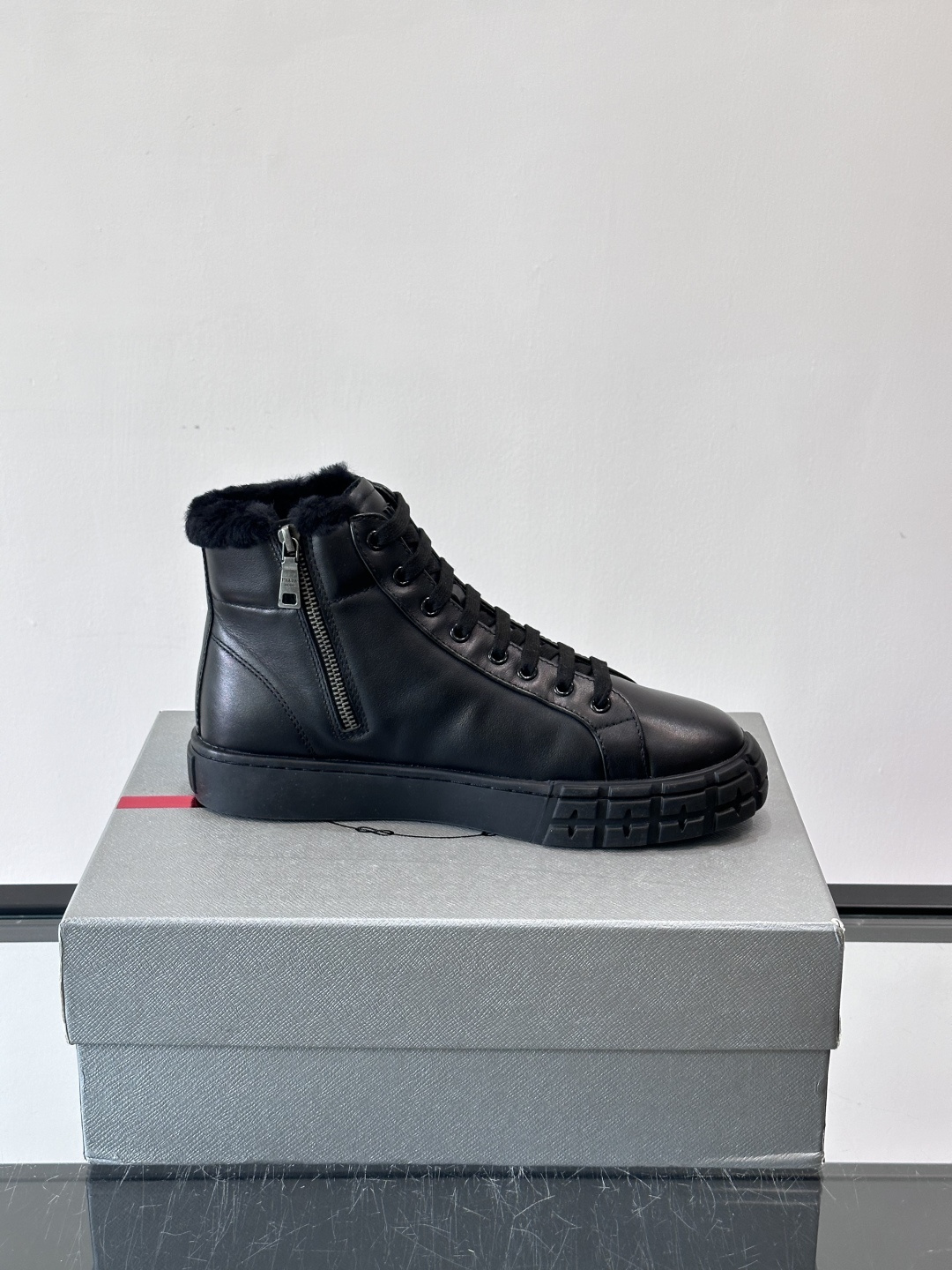 PRADA/普拉达 男士新款高帮运动鞋，这款厚底运动鞋采用牛皮鞋面制成，搭配加厚橡胶发泡中底拼接前后包裹