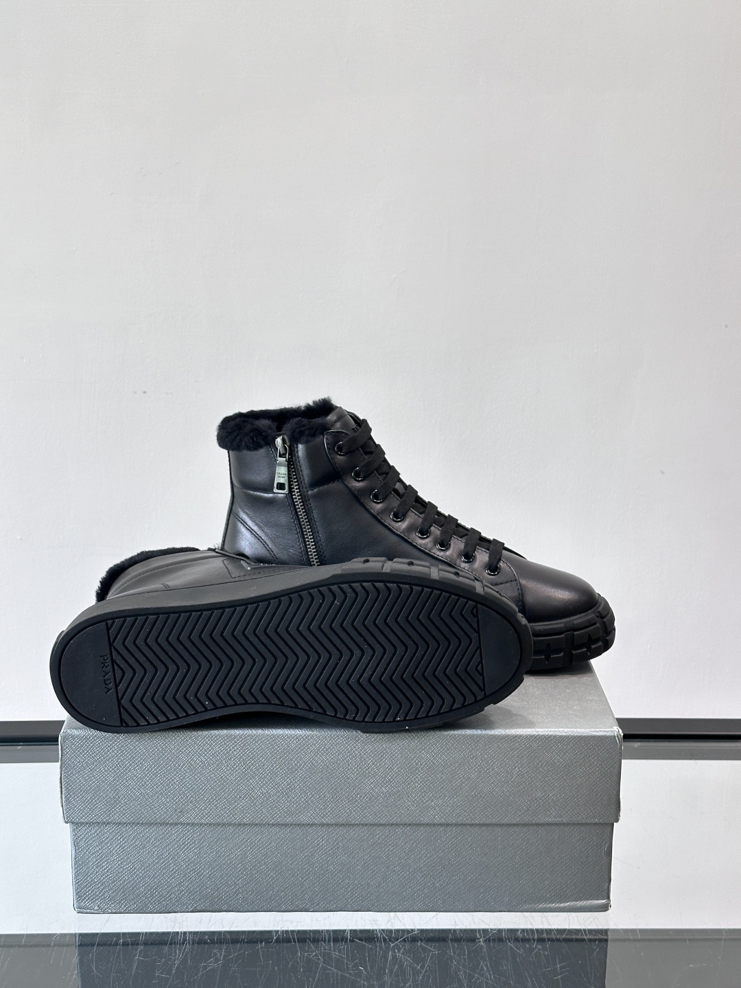 PRADA/普拉达 男士新款高帮运动鞋，这款厚底运动鞋采用牛皮鞋面制成，搭配加厚橡胶发泡中底拼接前后包裹