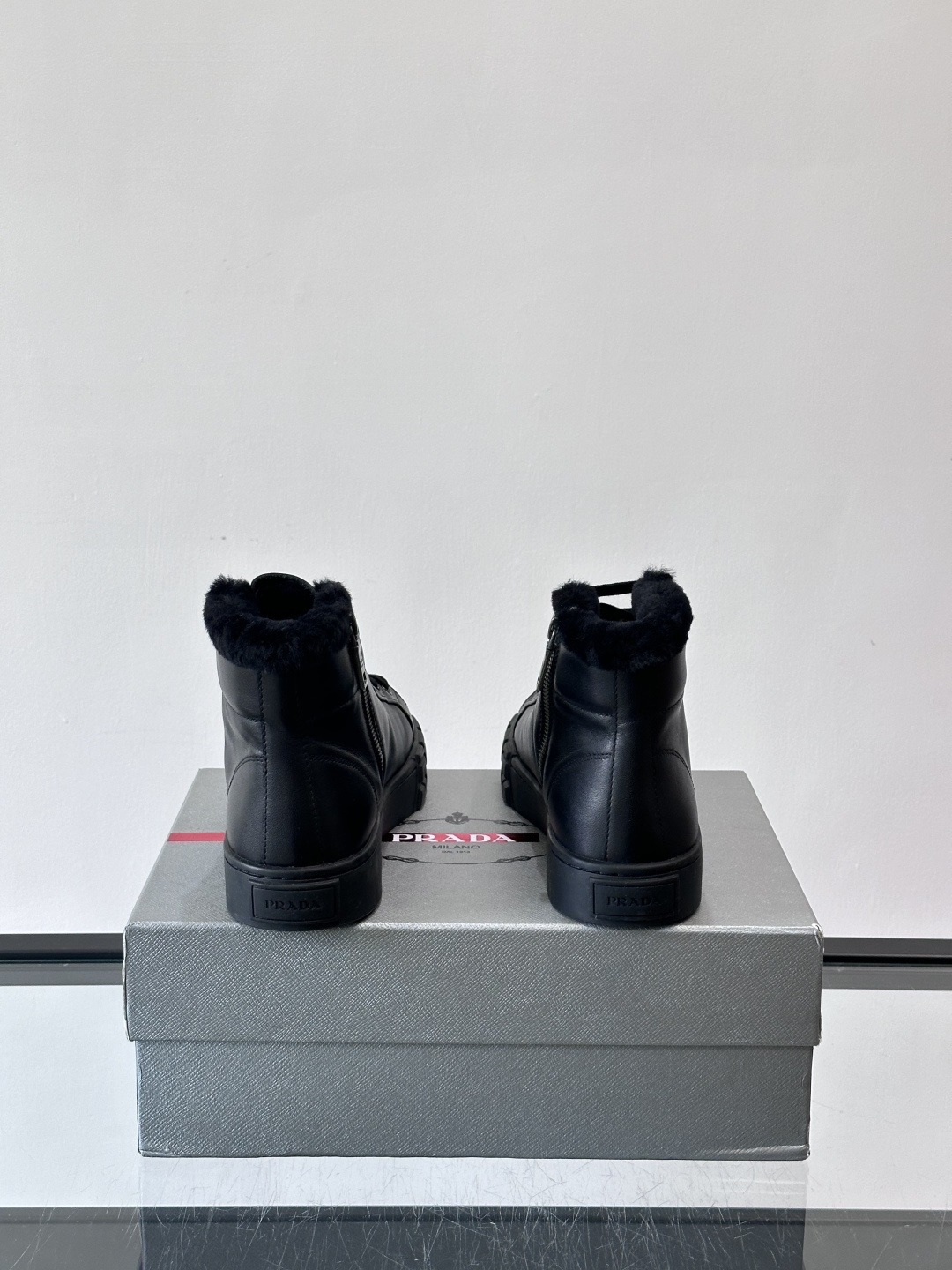 PRADA/普拉达 男士新款高帮运动鞋，这款厚底运动鞋采用牛皮鞋面制成，搭配加厚橡胶发泡中底拼接前后包裹