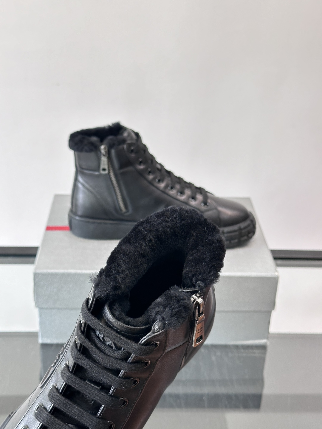 PRADA/普拉达 男士新款高帮运动鞋，这款厚底运动鞋采用牛皮鞋面制成，搭配加厚橡胶发泡中底拼接前后包裹