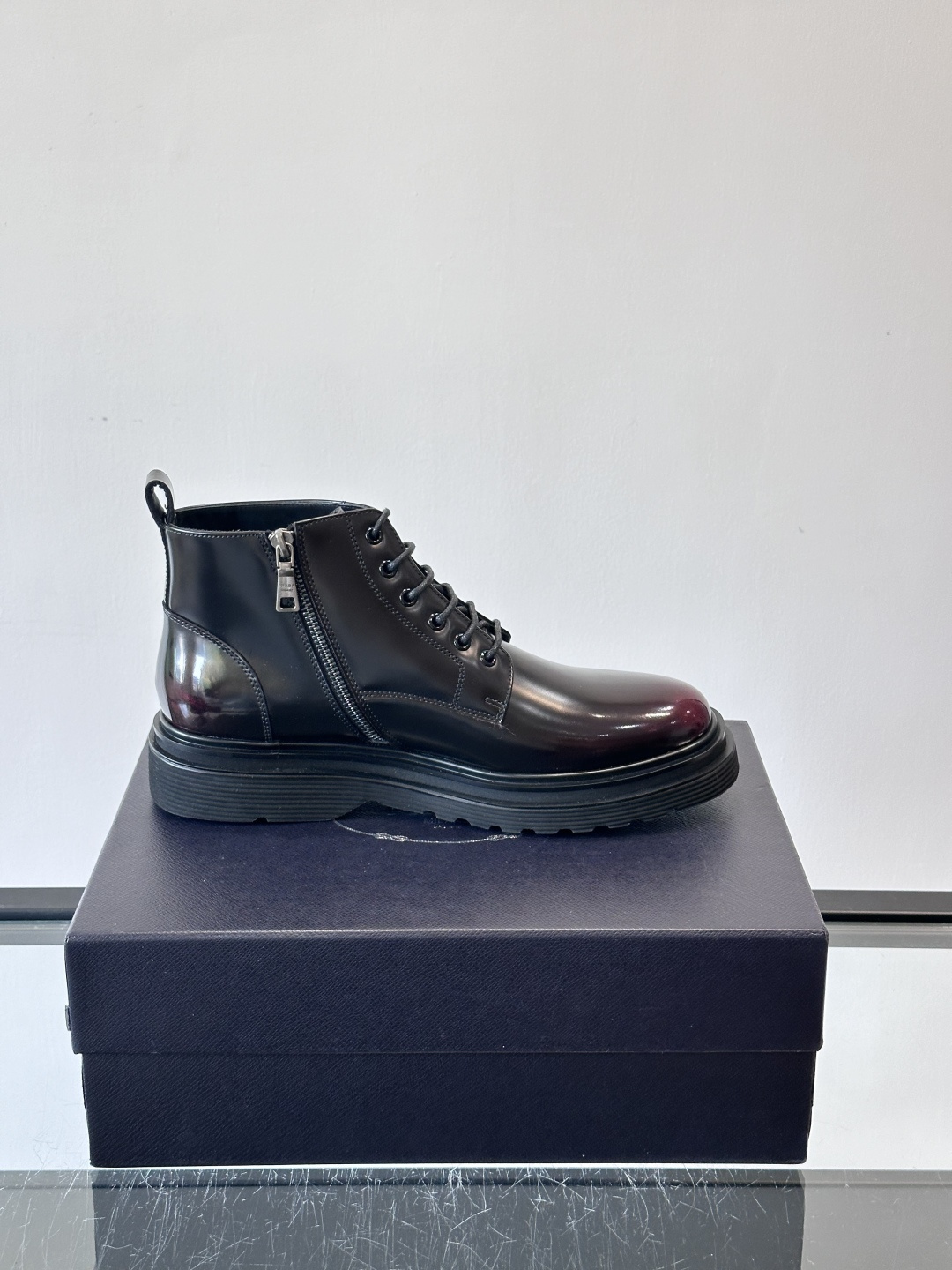 Prada这款男士商务马丁靴，选用优质牛皮，鞋面光滑有质感，搭配经典三角标，低调又有辦识度。厚底橡胶鞋底