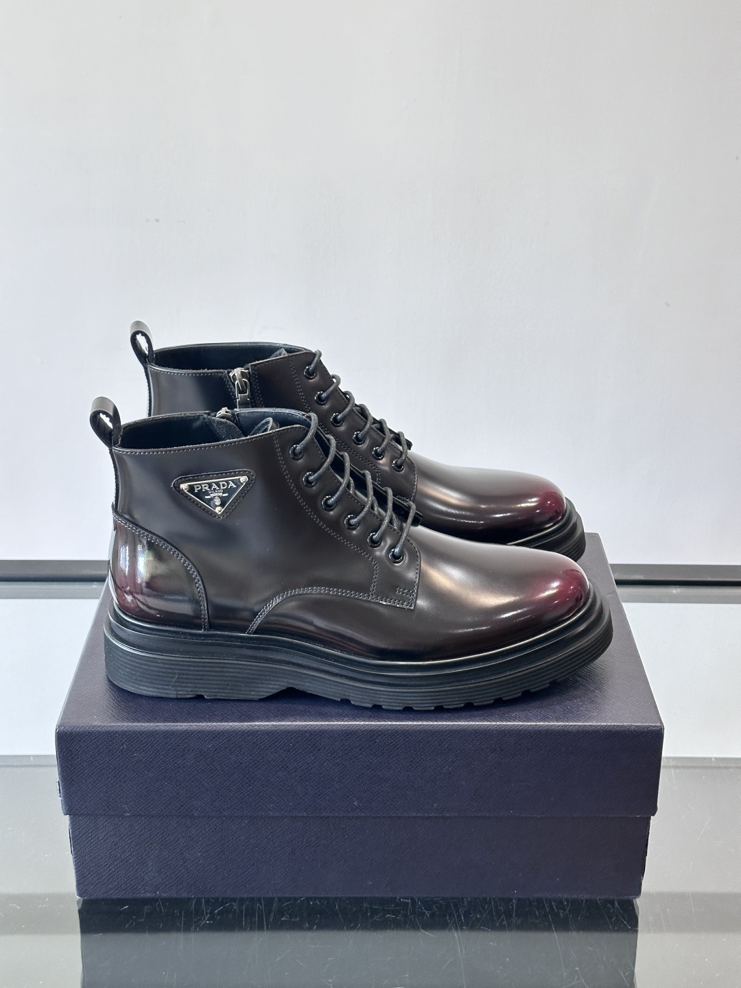 Prada这款男士商务马丁靴，选用优质牛皮，鞋面光滑有质感，搭配经典三角标，低调又有辦识度。厚底橡胶鞋底