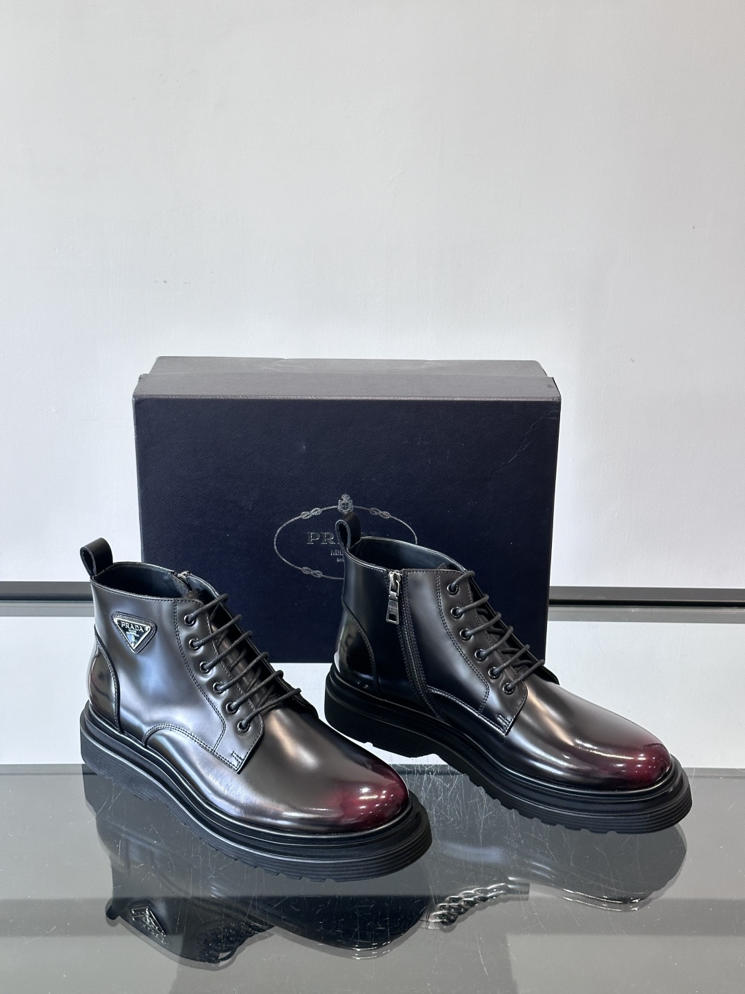 Prada这款男士商务马丁靴，选用优质牛皮，鞋面光滑有质感，搭配经典三角标，低调又有辦识度。厚底橡胶鞋底