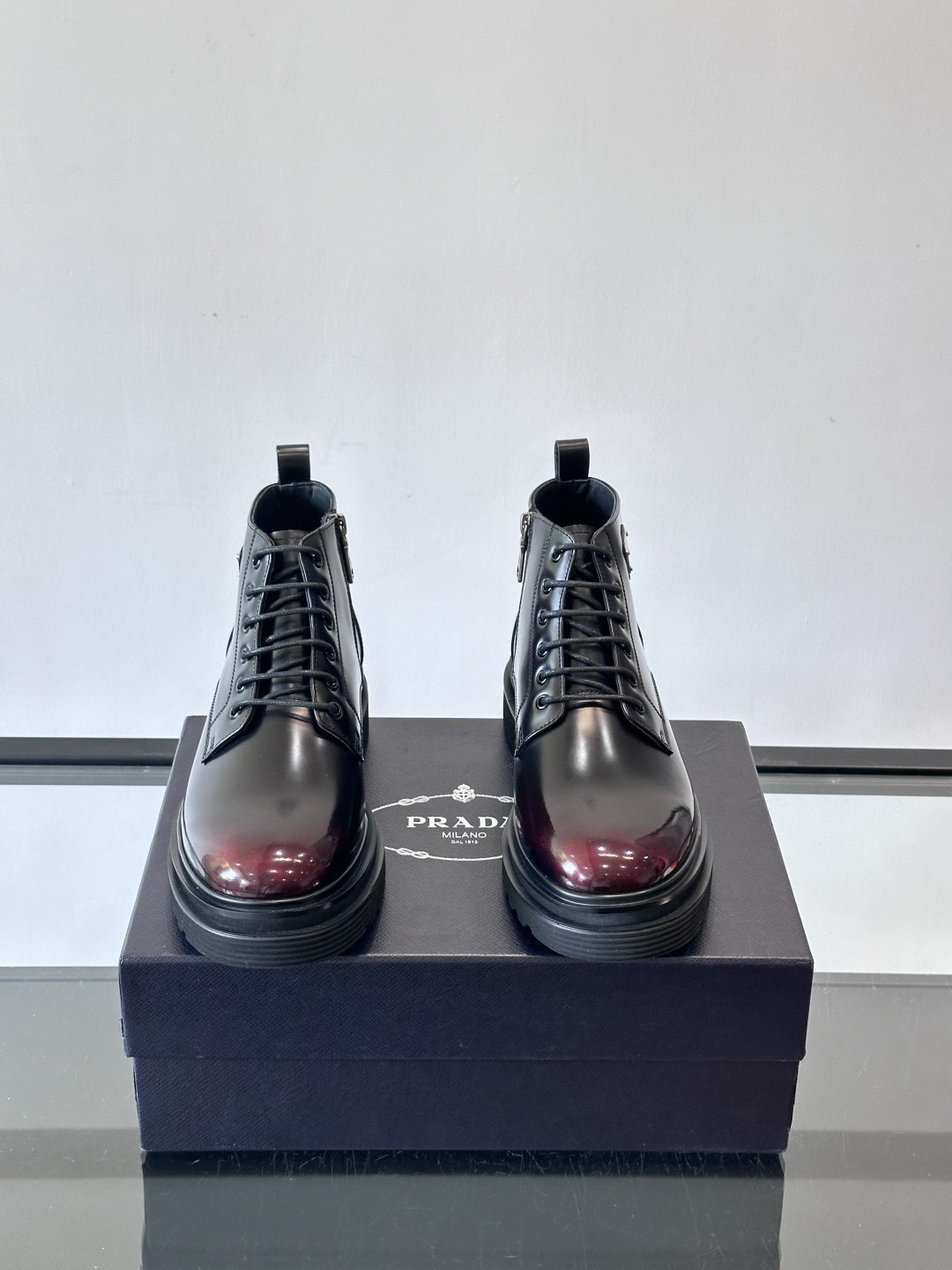 Prada这款男士商务马丁靴，选用优质牛皮，鞋面光滑有质感，搭配经典三角标，低调又有辦识度。厚底橡胶鞋底