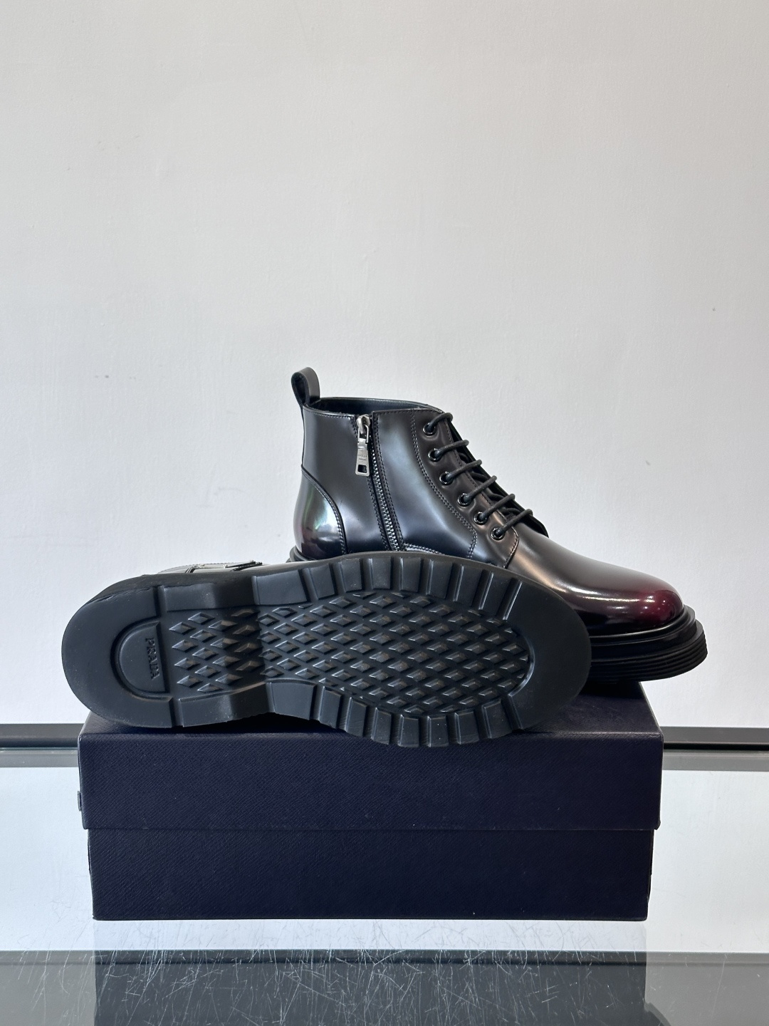 Prada这款男士商务马丁靴，选用优质牛皮，鞋面光滑有质感，搭配经典三角标，低调又有辦识度。厚底橡胶鞋底