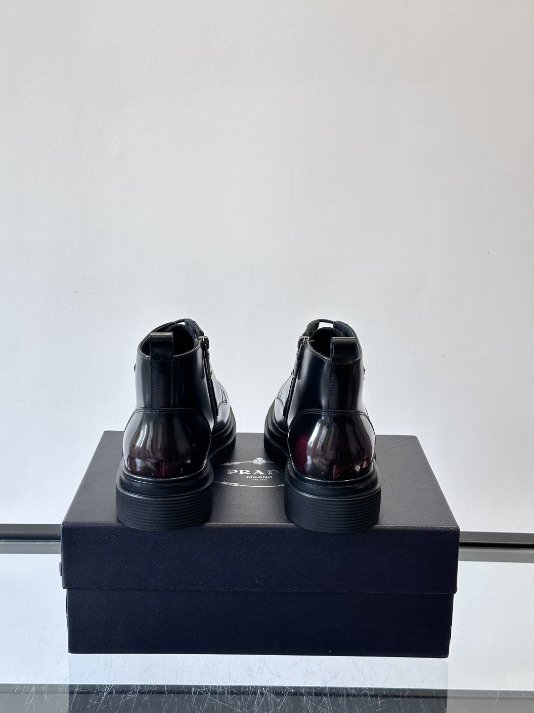 Prada这款男士商务马丁靴，选用优质牛皮，鞋面光滑有质感，搭配经典三角标，低调又有辦识度。厚底橡胶鞋底